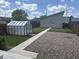 Well-maintained backyard with lush grass, a greenhouse, gravel section and detached garage at 1622 Cornell Ave, Indianapolis, IN 46202