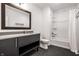 Bathroom features a gray vanity with a large mirror and a shower-tub combination with a white curtain at 1622 Cornell Ave, Indianapolis, IN 46202