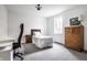 Neutral bedroom featuring a bed, desk, and dresser, illuminated by a window for ample natural light at 1622 Cornell Ave, Indianapolis, IN 46202
