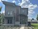 Contemporary two-story home boasts neutral siding, a balcony, unique wood accents, and meticulous landscaping at 1622 Cornell Ave, Indianapolis, IN 46202