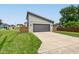 Detached garage with a gray door, a long driveway, a privacy fence, and a well-manicured lawn at 1622 Cornell Ave, Indianapolis, IN 46202