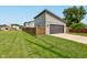 Detached garage with a dark gray door, a long driveway, a privacy fence, and a well-manicured lawn at 1622 Cornell Ave, Indianapolis, IN 46202
