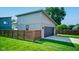 A modern garage with a gray door, lighting, and a wooden fence at 1622 Cornell Ave, Indianapolis, IN 46202