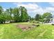Spacious backyard featuring a lush lawn, mature trees, and a lovely garden area at 164 Wellington Pkwy, Noblesville, IN 46060