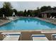 Community pool surrounded by lounge chairs and lush greenery, perfect for a refreshing swim at 164 Wellington Pkwy, Noblesville, IN 46060