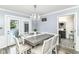 Elegant dining room with modern chandelier, grey table and access to pool at 164 Wellington Pkwy, Noblesville, IN 46060