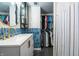 Updated bathroom features blue backsplash, white vanity, mirror, and a closet at 250 N 18Th Ave, Beech Grove, IN 46107