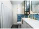 Updated bathroom features blue backsplash, white vanity, storage cabinets, and a shower curtain at 250 N 18Th Ave, Beech Grove, IN 46107