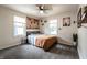 Bright bedroom features a modern ceiling fan, gray carpet, and two windows to allow natural light at 250 N 18Th Ave, Beech Grove, IN 46107