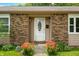 Close-up of the front entrance with a decorative white door and blooming flowers at 3210 Flintwood Dr, Columbus, IN 47203