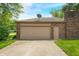 Attached garage with an automatic door and a well-maintained driveway at 3210 Flintwood Dr, Columbus, IN 47203