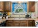 Close up of a kitchen sink area with oak cabinets and a window at 3210 Flintwood Dr, Columbus, IN 47203