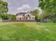 Expansive backyard featuring a spacious lawn, wooden pergola, and black metal fence at 4075 Dartmoor Dr, Greenwood, IN 46143
