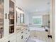 Bright bathroom features double vanity, vessel sinks, and a separate tub under a window at 4075 Dartmoor Dr, Greenwood, IN 46143