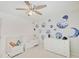 Bedroom with a crib, dresser, and planet wall decorations at 4075 Dartmoor Dr, Greenwood, IN 46143