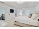 Sunlit bedroom with a tray ceiling, mounted TV, and seamless access to an ensuite bathroom at 4075 Dartmoor Dr, Greenwood, IN 46143