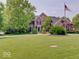 Charming two-story brick home featuring a lush green lawn and mature trees at 4075 Dartmoor Dr, Greenwood, IN 46143