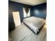 Bedroom with blue walls, wood-look flooring, and a large window at 4108 Patricia St, Indianapolis, IN 46222