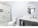 Modern bathroom featuring a marble tiled shower, round mirror, and a vanity with white countertop at 422 Sanders St, Indianapolis, IN 46225