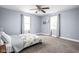 Spacious bedroom with two windows, neutral carpet, ceiling fan, and light blue walls at 422 Sanders St, Indianapolis, IN 46225