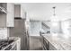 Spacious kitchen with stainless steel appliances, a large stone-topped island, and view of the staircase at 422 Sanders St, Indianapolis, IN 46225