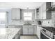 Well-equipped kitchen with white cabinets, granite countertops, stainless steel appliances, and a mosaic backsplash at 422 Sanders St, Indianapolis, IN 46225