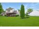 Spacious backyard with a lush green lawn, mature trees, and a covered patio perfect for outdoor enjoyment at 4442 Victory Cir, Indianapolis, IN 46203