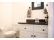 This bathroom features a black granite countertop and vanity and modern toilet at 4442 Victory Cir, Indianapolis, IN 46203