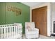 Bedroom features a comfortable glider and whimsical decor, complemented by an accent wall and ample storage at 4442 Victory Cir, Indianapolis, IN 46203