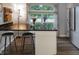 Stylish kitchen island with black countertop and seating, complemented by stainless steel appliances and natural light at 4442 Victory Cir, Indianapolis, IN 46203