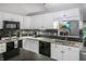 Modern kitchen with white cabinets, black appliances, and a breakfast bar, open to the living space at 4442 Victory Cir, Indianapolis, IN 46203
