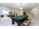 Well lit basement featuring a pool table with open drawers, staircase and leather recliners at 4763 Woods Edge Dr, Zionsville, IN 46077