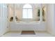 Relaxing bathroom featuring a large soaking tub with decorative pillars and a window for natural light at 4763 Woods Edge Dr, Zionsville, IN 46077