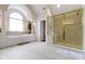 Spacious bathroom with a large tub, shower with gold trim, and tile flooring for a luxurious feel at 4763 Woods Edge Dr, Zionsville, IN 46077