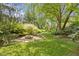 Inviting backyard fire pit area with stone seating and a surrounding green lawn, perfect for outdoor gatherings at 4763 Woods Edge Dr, Zionsville, IN 46077