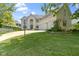 Beautiful white brick house with an expansive front lawn, landscaped with trees and manicured shrubs at 4763 Woods Edge Dr, Zionsville, IN 46077