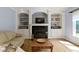 Living room features fireplace with black tile and built-in shelving, with natural light from the window at 4763 Woods Edge Dr, Zionsville, IN 46077