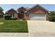 Charming brick home featuring a two-car garage and a well-maintained front lawn at 5148 Constitution Ct, Columbus, IN 47203