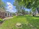 Expansive backyard showing detached garage, green grass, bird bath, and mature trees at 5240 Southdale Dr, Indianapolis, IN 46217