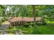 A charming brick ranch home with a well-maintained lawn and mature trees under a blue sky at 5240 Southdale Dr, Indianapolis, IN 46217
