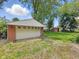 Detached garage with white door and brick walls set in green backyard at 5240 Southdale Dr, Indianapolis, IN 46217