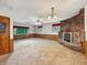Spacious living room with a brick fireplace, paneled walls, and natural light at 5240 Southdale Dr, Indianapolis, IN 46217