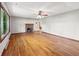 Bright living room with hardwood floors, a ceiling fan, and a cozy brick fireplace at 5240 Southdale Dr, Indianapolis, IN 46217