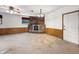 Cozy den featuring brick fireplace, carpeted floors, ceiling fan and wood paneling at 5240 Southdale Dr, Indianapolis, IN 46217
