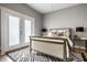 Bright bedroom featuring a comfortable bed, stylish rug, and french doors to the outside at 529 E Merrill St, Indianapolis, IN 46203
