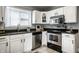 Well-lit kitchen with stainless steel appliances, white cabinets, and dark countertops at 529 E Merrill St, Indianapolis, IN 46203