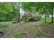 Large backyard featuring a deck and stone patio with seating nestled in lush greenery at 5441 Ellsworth Dr, Plainfield, IN 46168