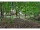 Lush backyard featuring a multi-level deck, patio with seating and wooded backdrop at 5441 Ellsworth Dr, Plainfield, IN 46168