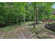 Secluded backyard with stone patio, fire pit, outdoor seating, and wooded backdrop at 5441 Ellsworth Dr, Plainfield, IN 46168