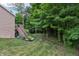 Green backyard includes a staircase leading to a deck, a well-manicured lawn, and lush trees at 5441 Ellsworth Dr, Plainfield, IN 46168